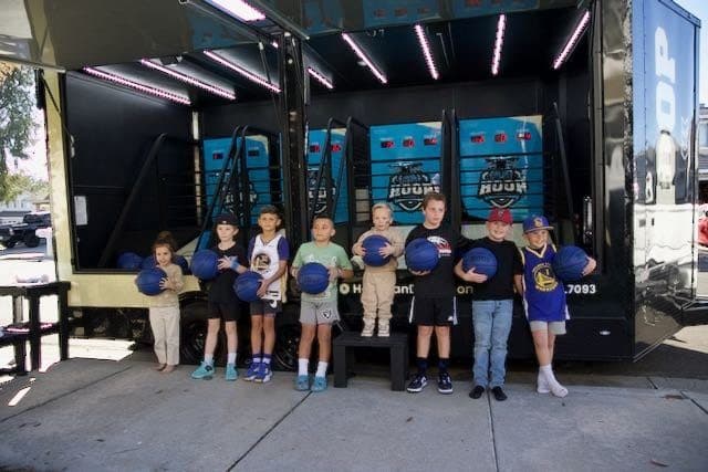 Kids lined up holding HOOP basketballs at a birthday party